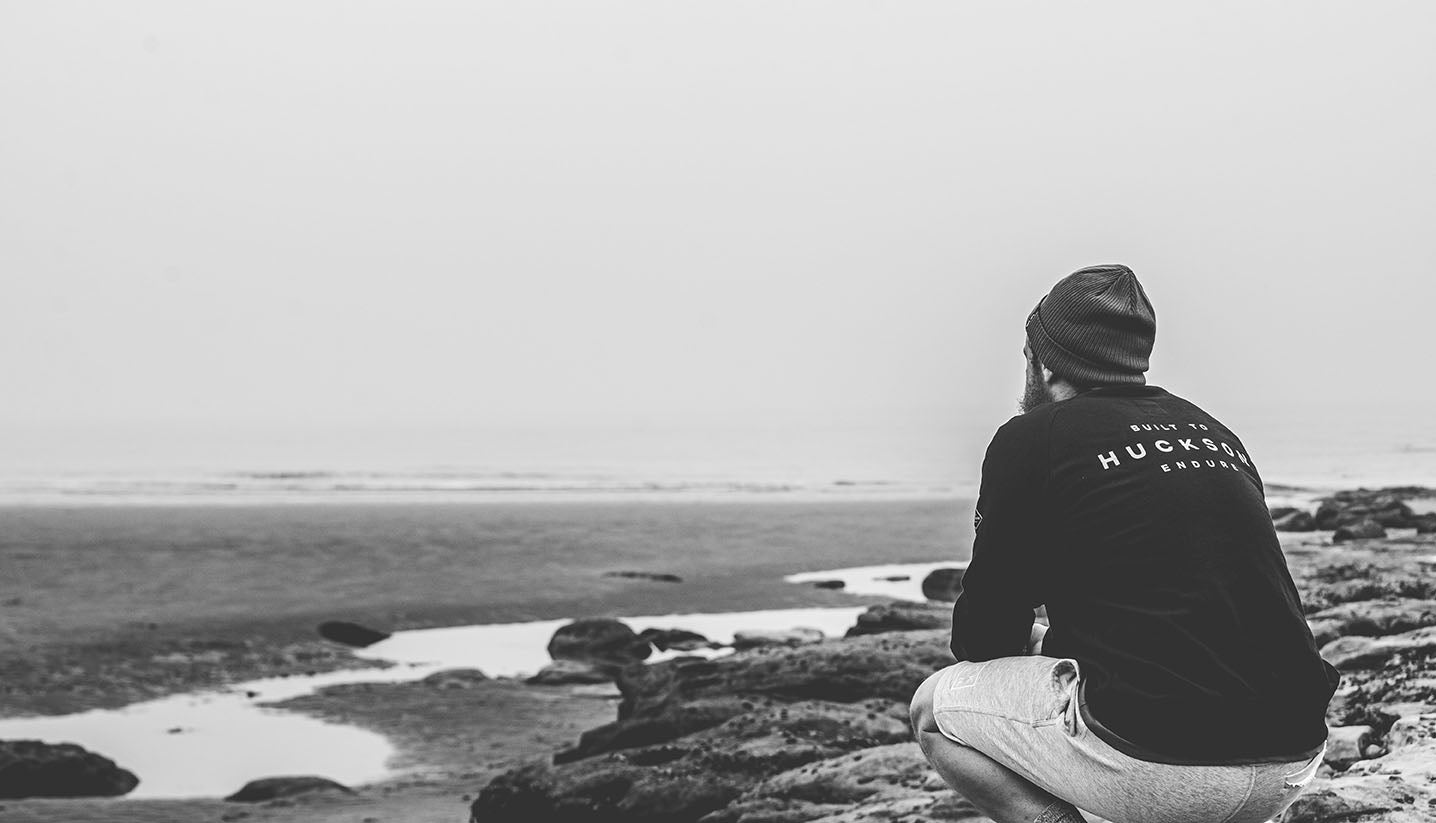 Male sits by beach