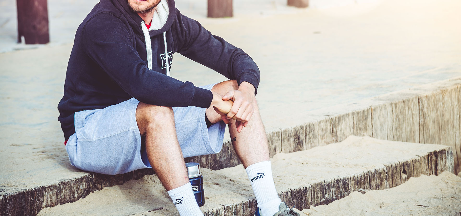 Man sits by beach 